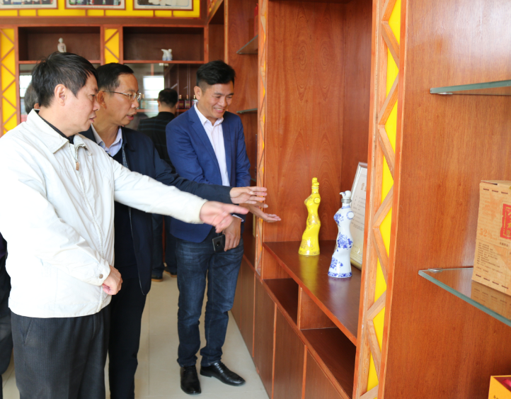 11.12市供銷社黨組書記、理事會主任唐甫忠對雅大獨特的酒瓶設(shè)計所吸引